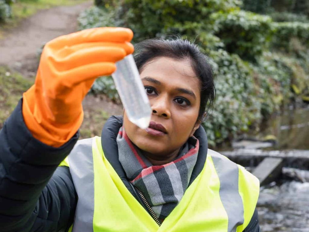 a woman collecting a water sample for PFAS contamination